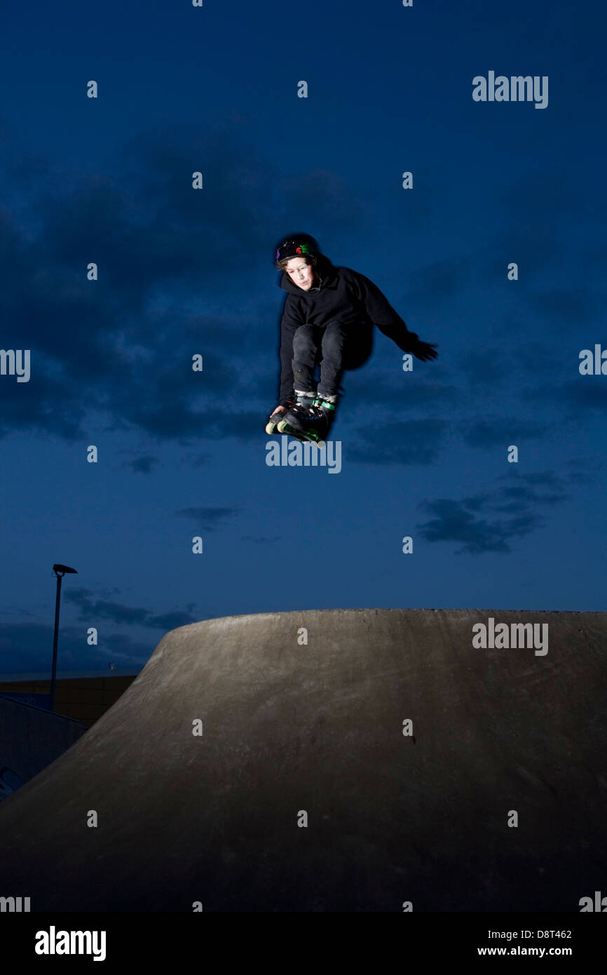 Young Inline skater jumping in a skate park. Stock Photo