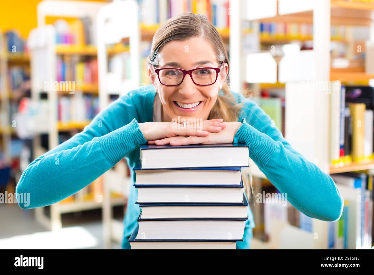 Student - young woman or girl sitting with books in library learning ...