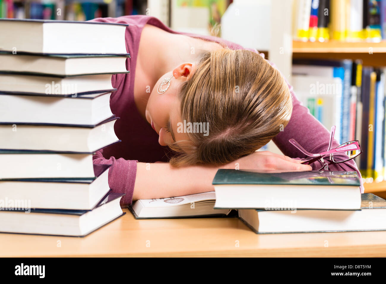 Tired Library Student - Young woman in library with books learning, she is asleep ...