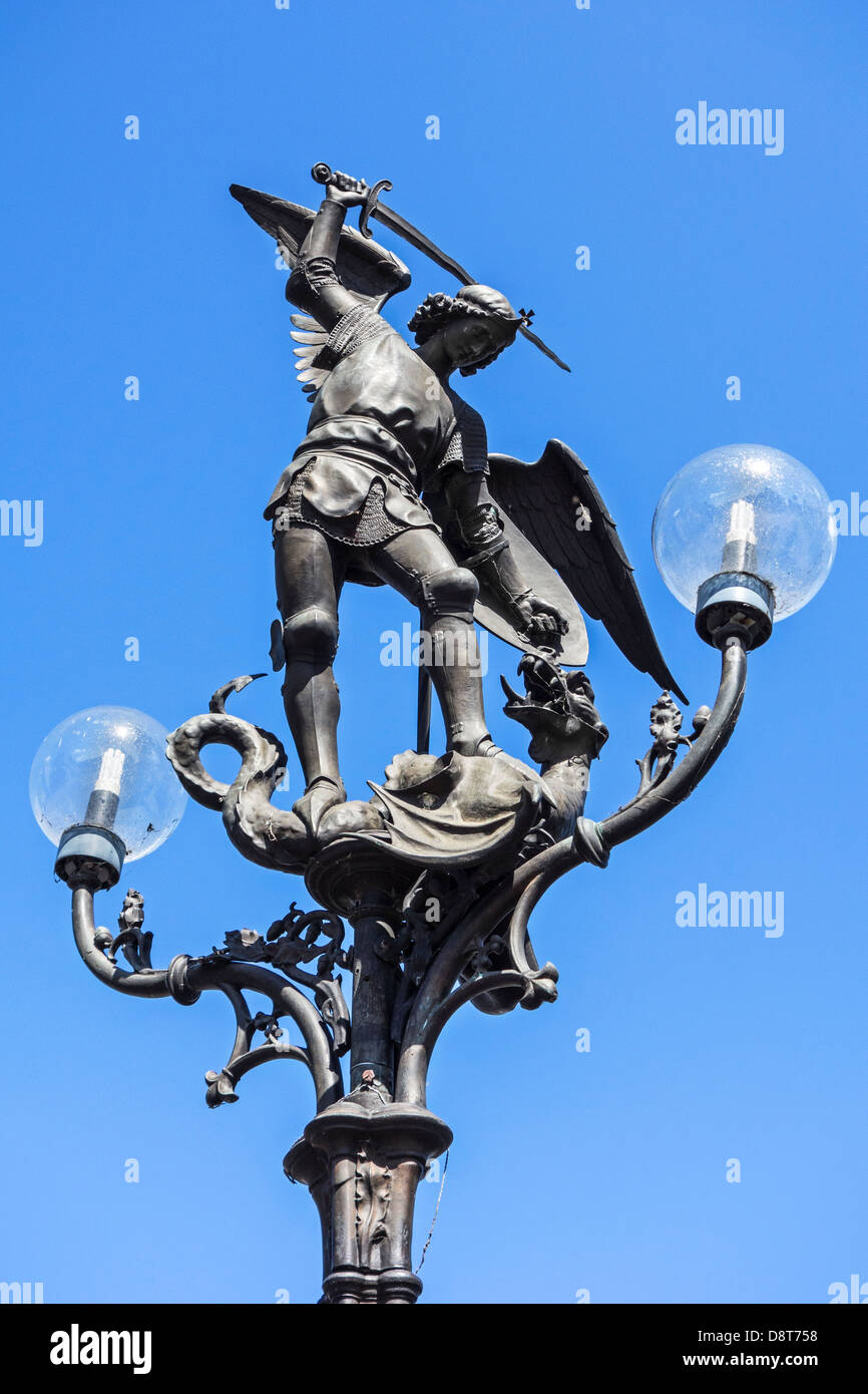 Lamppost with statue of Archangel Michael slaying Satan as a dragon at the Saint Michael's bridge in Ghent, Belgium Stock Photo