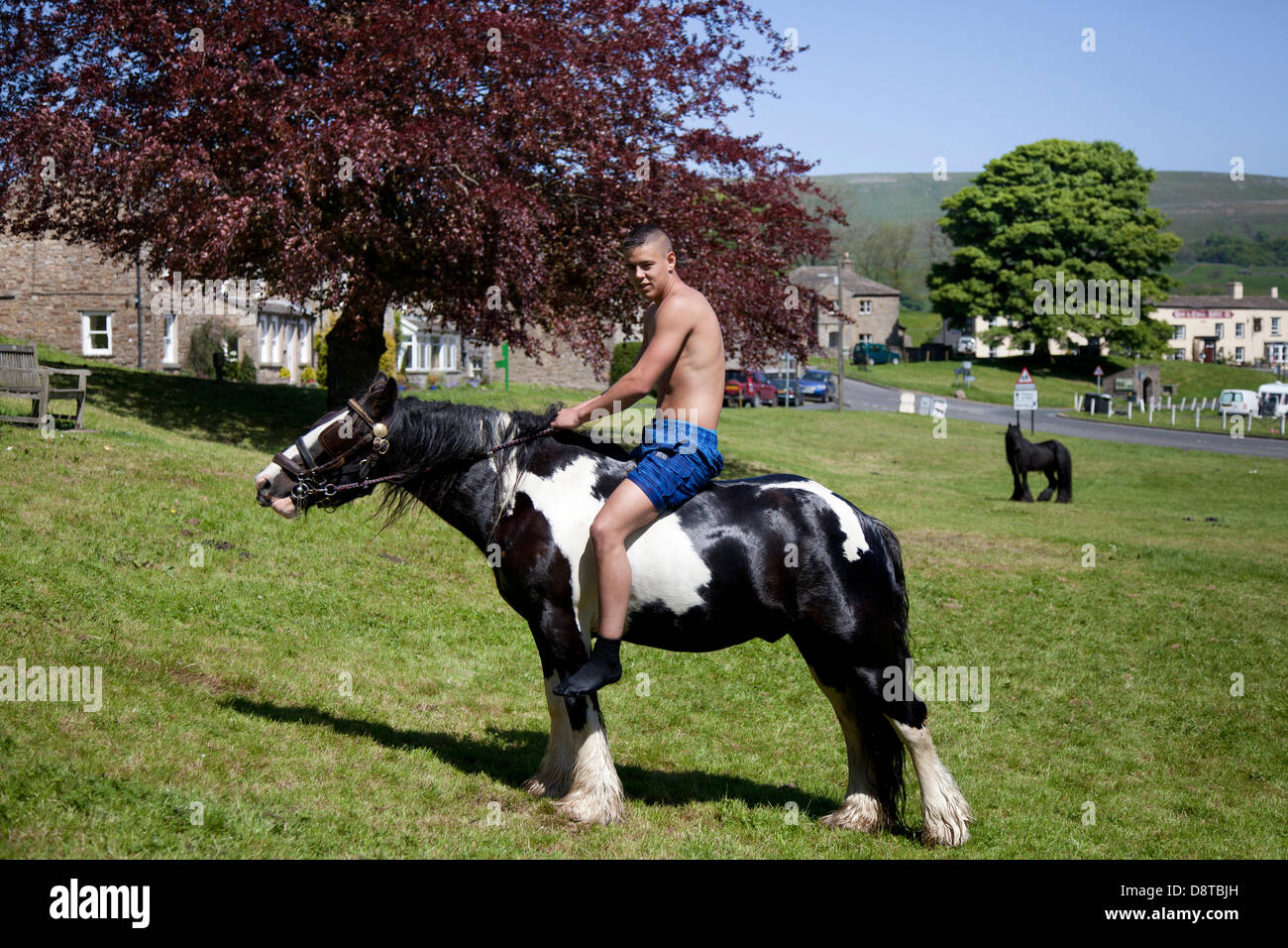 Gypsy travellers in Bainbridge, Richmondshire, North Yorkshire, UK. 4th June, 2013. Brad Hill, 17 riding a Cob horse on the village green a member of the travelling community en-route to the Appleby Horse Fair in Cumbria.  The Fair is an annual gathering of Gypsies and Travellers which takes place on the first week in June, and has taken place since the reign of James II, who granted a Royal charter in 1685 allowing a horse fair 'near to the River Eden'. Stock Photo