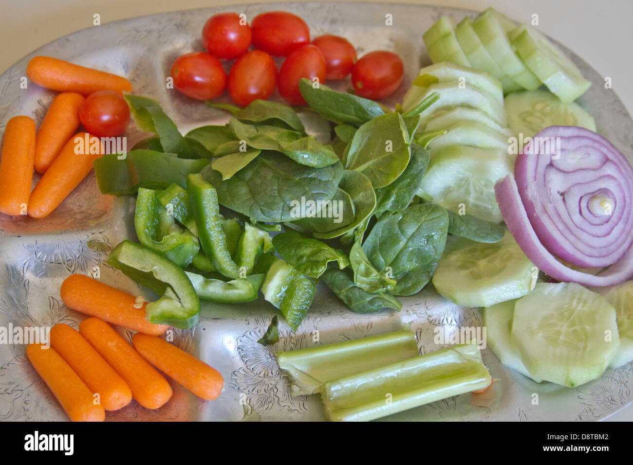 A silver platter heaping with colorful, raw, organic produce ready for