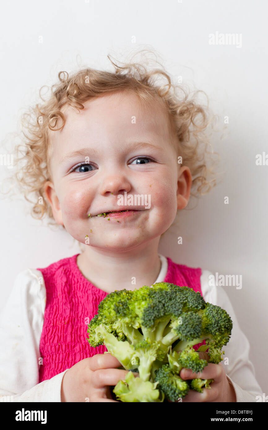 Young girl eating broccoli Stock Photo Alamy