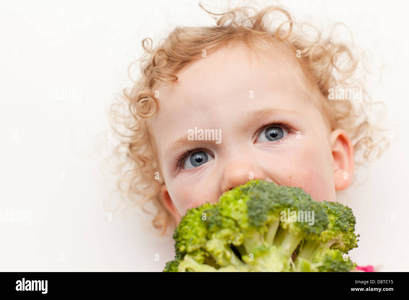 Young girl eating broccoli Stock Photo Alamy