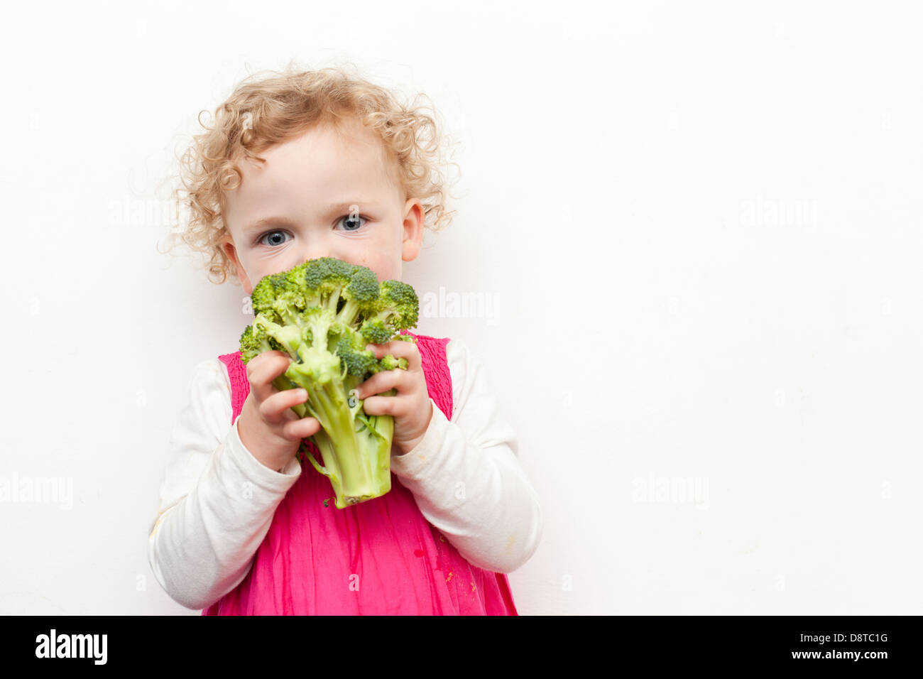 Young girl eating broccoli Stock Photo Alamy
