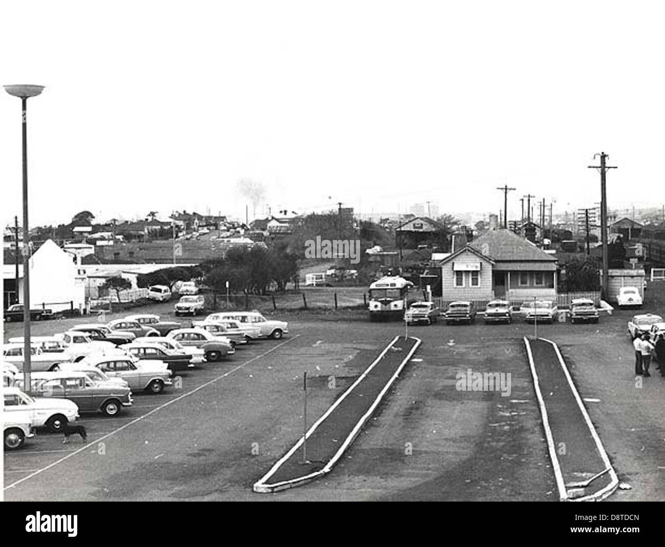 The black-and-white image of Wollongong Railway Station, located in New South Wales, captures the station's architecture and surrounding vehicles. The photo is a historical representation of regional transportation in the Illawarra region, providing insight into the area's development and railway history. Stock Photo
