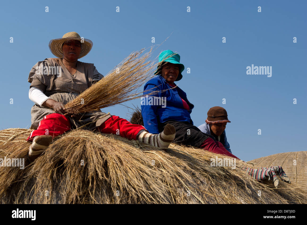 Woman thatching a hut at Ondini Heritage Site, Recreation of King Cetshwayo's residence at Ondini, Ulundi, South Africa Stock Photo