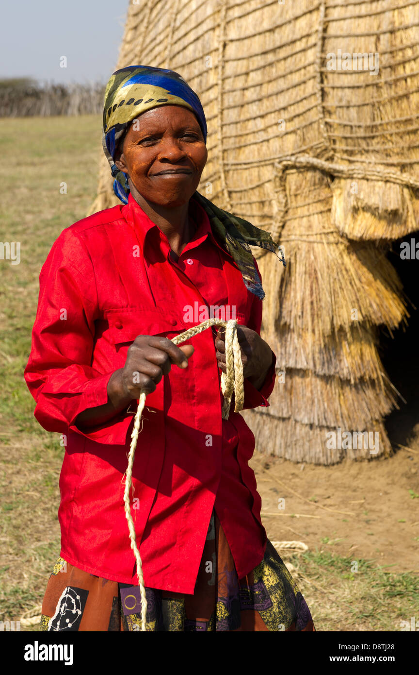 Woman thatching a hut at Ondini Heritage Site, Recreation of King Cetshwayo's residence at Ondini, Ulundi, South Africa Stock Photo