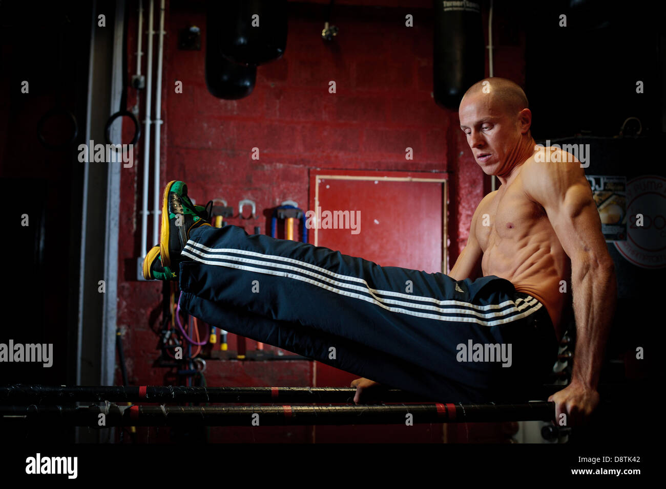 Personal Trainer Rhys John, working out with series of body weight exercises in a gym. Stock Photo
