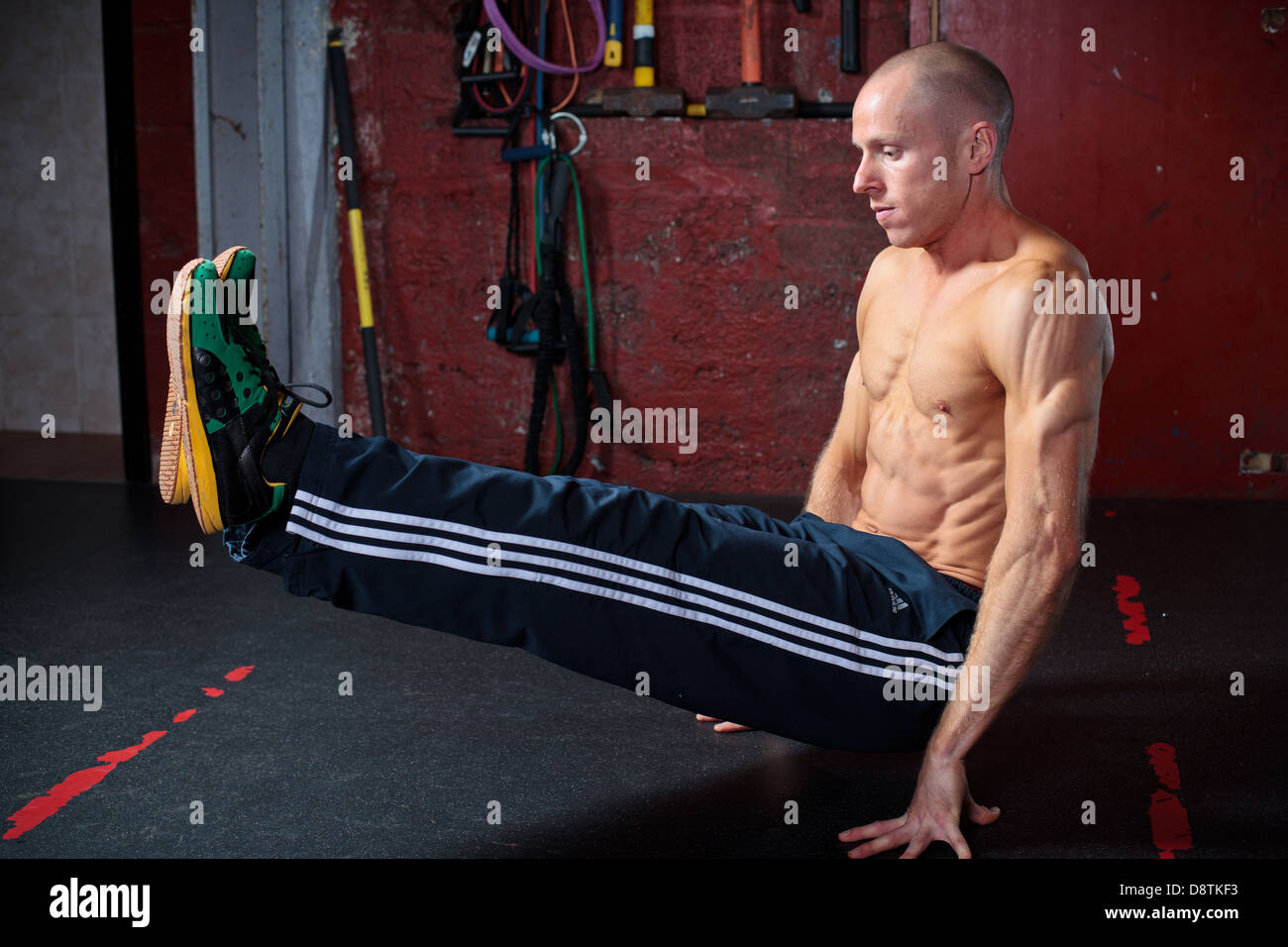 Personal Trainer Rhys John, working out with series of body weight exercises in a gym. Stock Photo