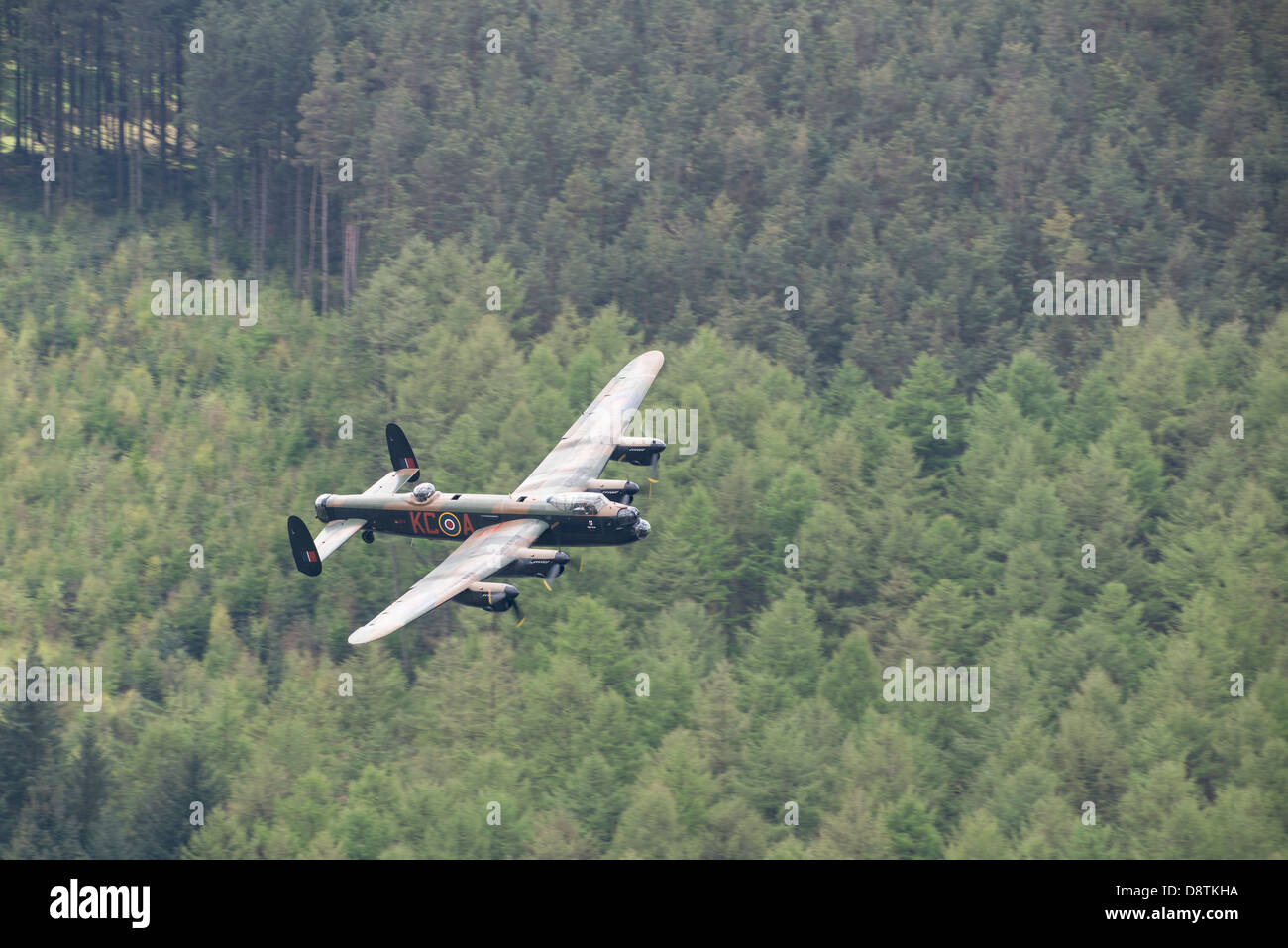 The Battle of Britain Memorial Flight (BBMF) Avro Lancaster flies low over the trees in the Upper Derwent Valley Stock Photo