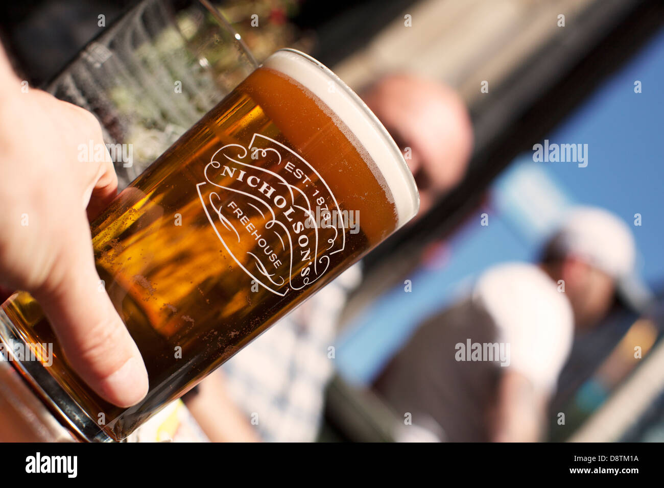 A pint of real ale in the sunshine in the beer garden of a British pub,Nicholson's pub chain Stock Photo