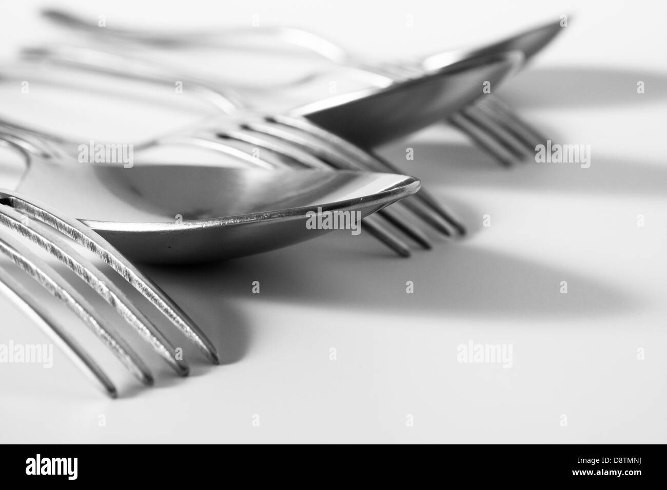forks and spoons on a white table Stock Photo