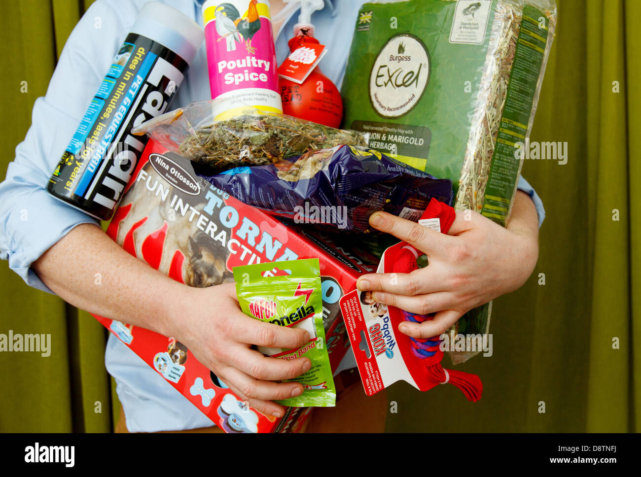 A man holds a large amount of pet related food, bedding and animal products Stock Photo