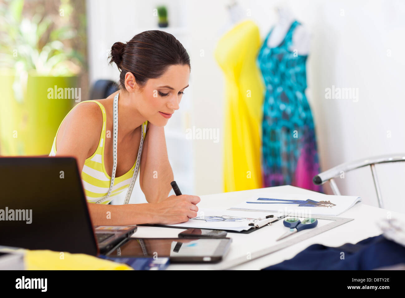 pretty female fashion designer drawing new designs Stock Photo - Alamy