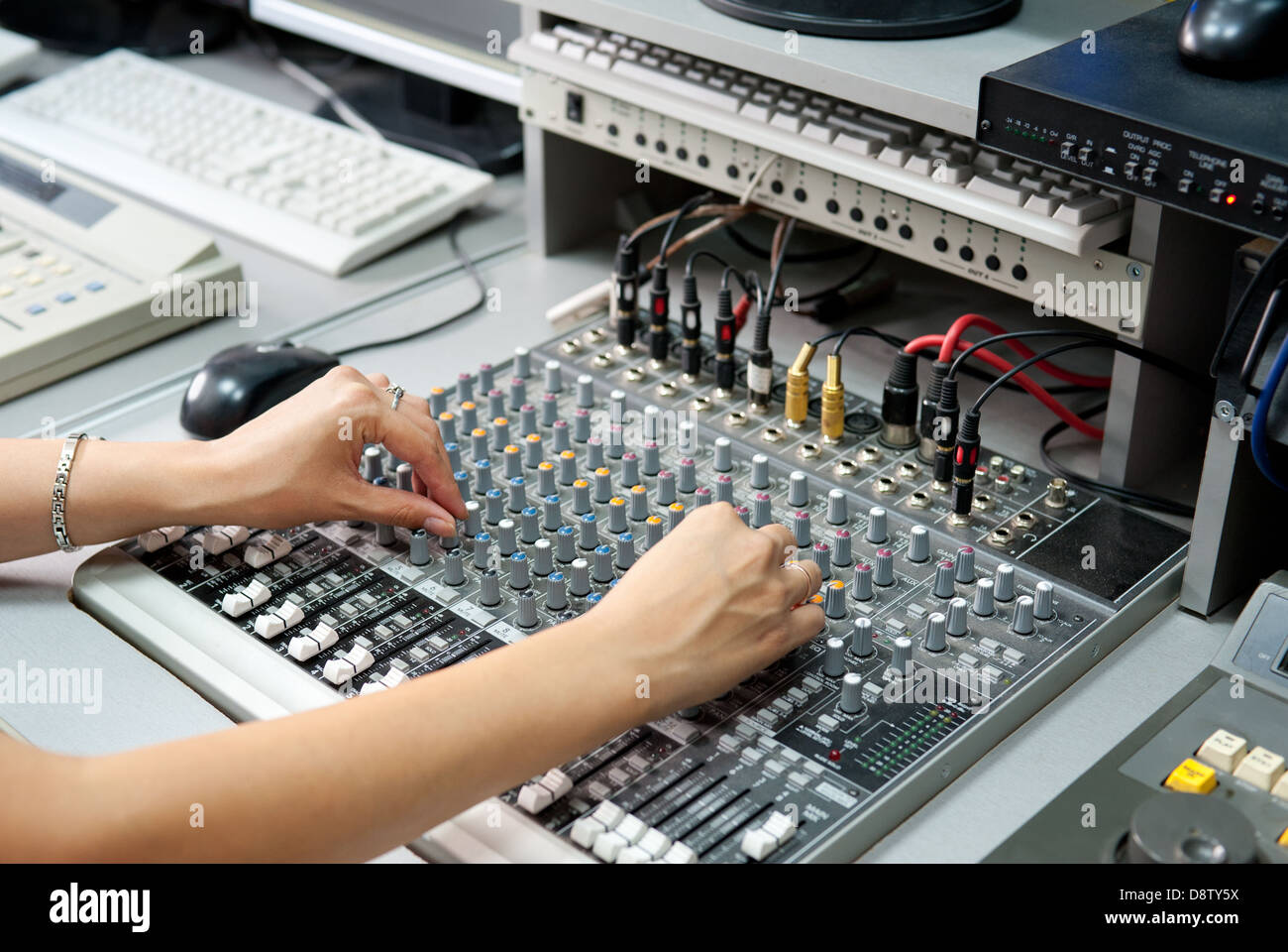 female hands at audio control console Stock Photo