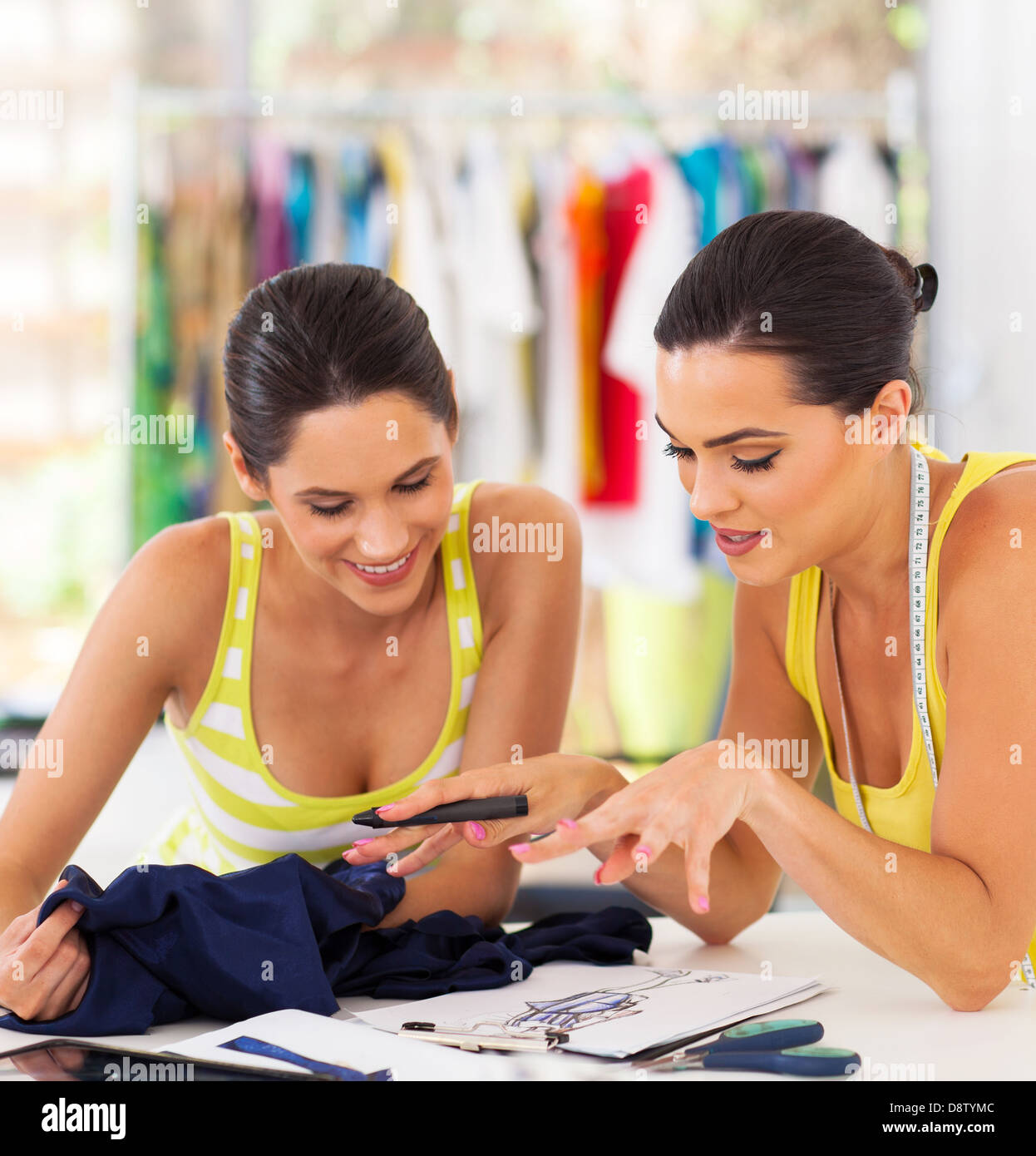 pretty dressmaker showing a new design to her client Stock Photo - Alamy