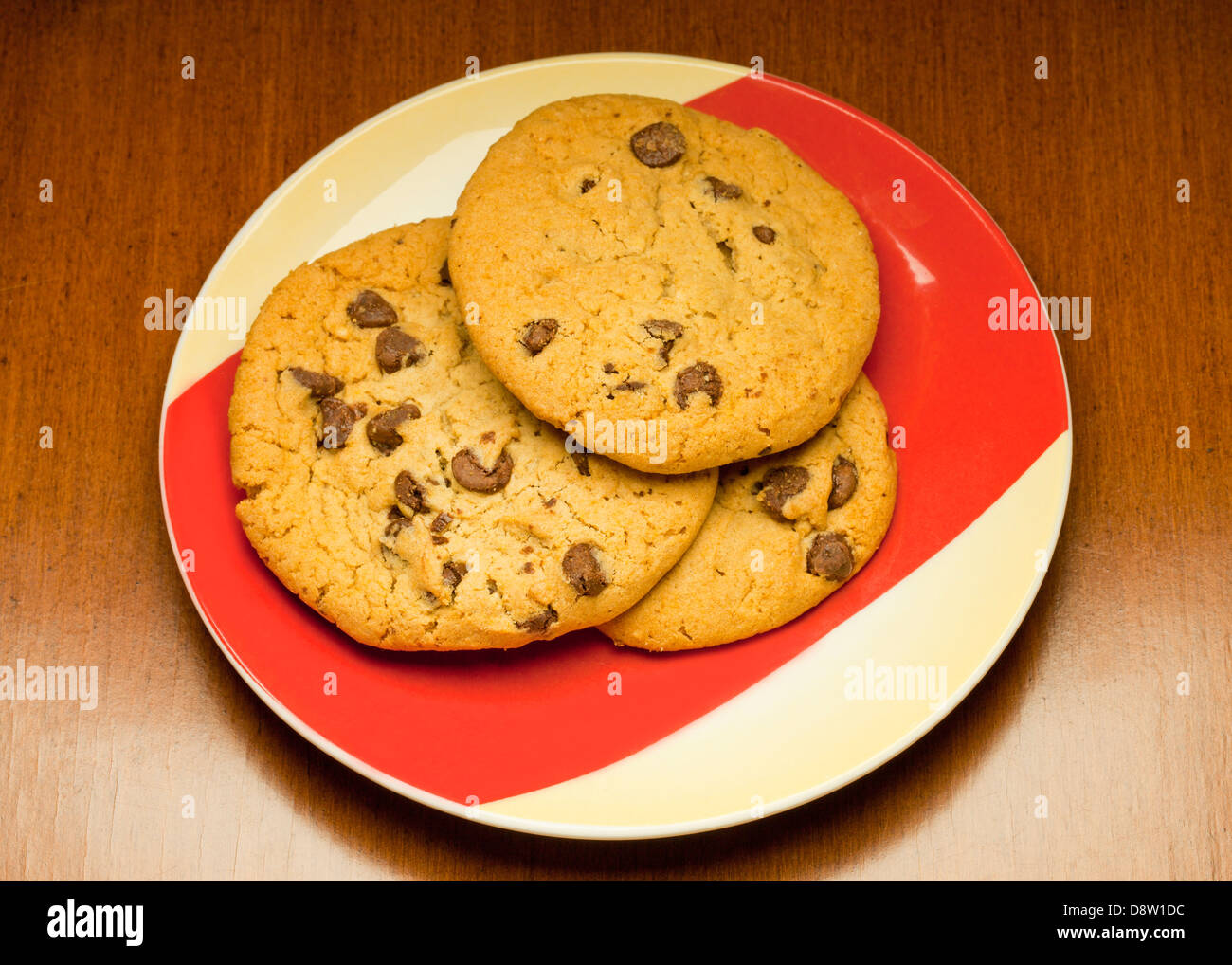 Three chocolate chip cookies on plate Stock Photo