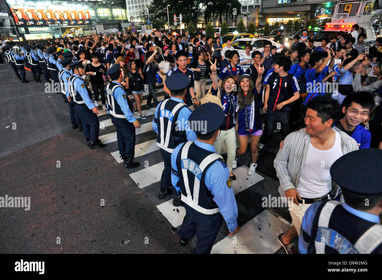 Saitama, Japan. 4th June 2013. June 4th, 2013 : Tokyo, Japan - Fans celebrated the Japan National Soccer team, which had a game of the final Asian qualifiers for the 2014 World Cup against Australia and cleared it, as police officers regulate them in front of Shibuya Station, Shibuya, Tokyo Japan on June 4, 2013.  (Photo by Koichiro Suzuki/AFLO/Alamy Live News) Stock Photo