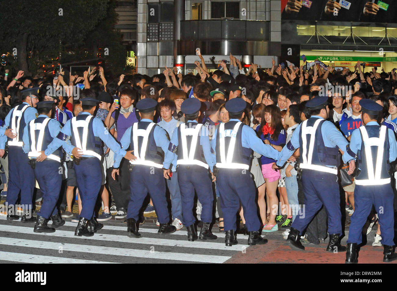Saitama, Japan. 4th June 2013. June 4th, 2013 : Tokyo, Japan - Police Officers restricted pedestrians and celebrating fans of the Japan National Soccer team, which had a game of the final Asian qualifiers for the 2014 World Cup against Australia and cleared it, in front of Shibuya Station, Shibuya, Tokyo Japan on June 4, 2013.  (Photo by Koichiro Suzuki/AFLO/Alamy Live News) Stock Photo