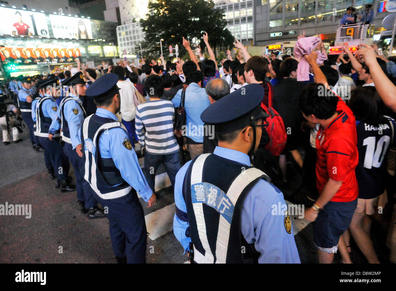Saitama, Japan. 4th June 2013. June 4th, 2013 : Tokyo, Japan - Fans celebrated the Japan National Soccer team, which had a game of the final Asian qualifiers for the 2014 World Cup against Australia and cleared it, as police officers regulate them in front of Shibuya Station, Shibuya, Tokyo Japan on June 4, 2013.  (Photo by Koichiro Suzuki/AFLO/Alamy Live News) Stock Photo