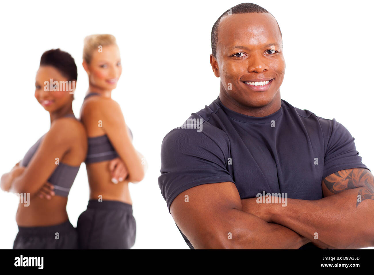 cheerful african male personal trainer and two gym members on background Stock Photo