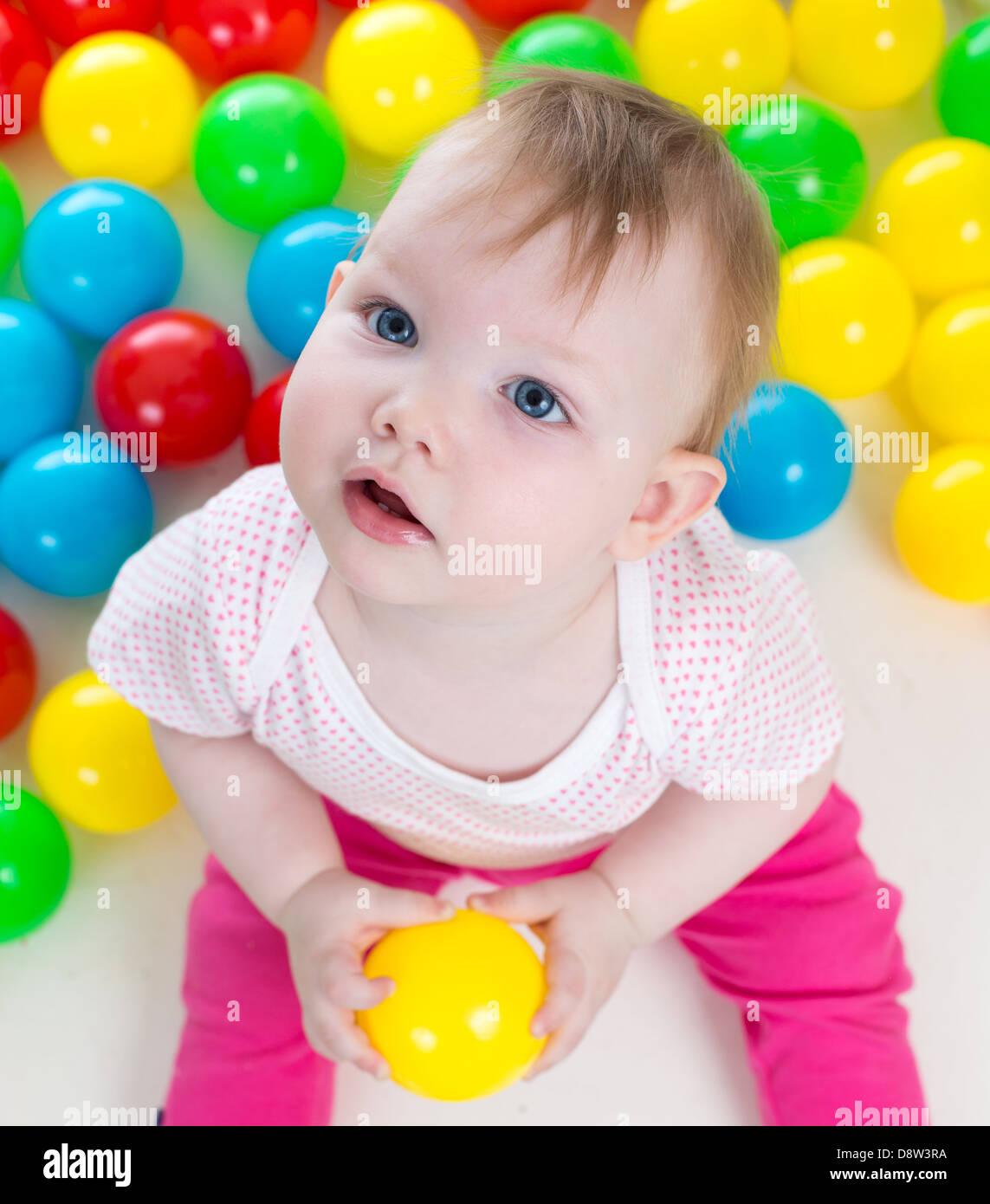 Top view of baby girl playing with colorful balls Stock Photo