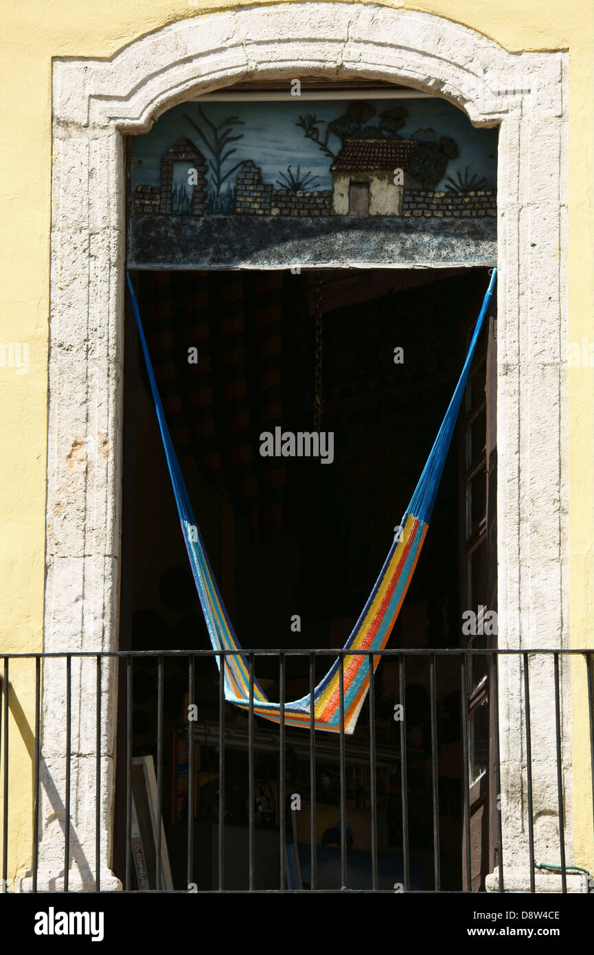 Colourful lone hammock hanging in the open window of a store in Merida, Yucatan, Mexico Stock Photo