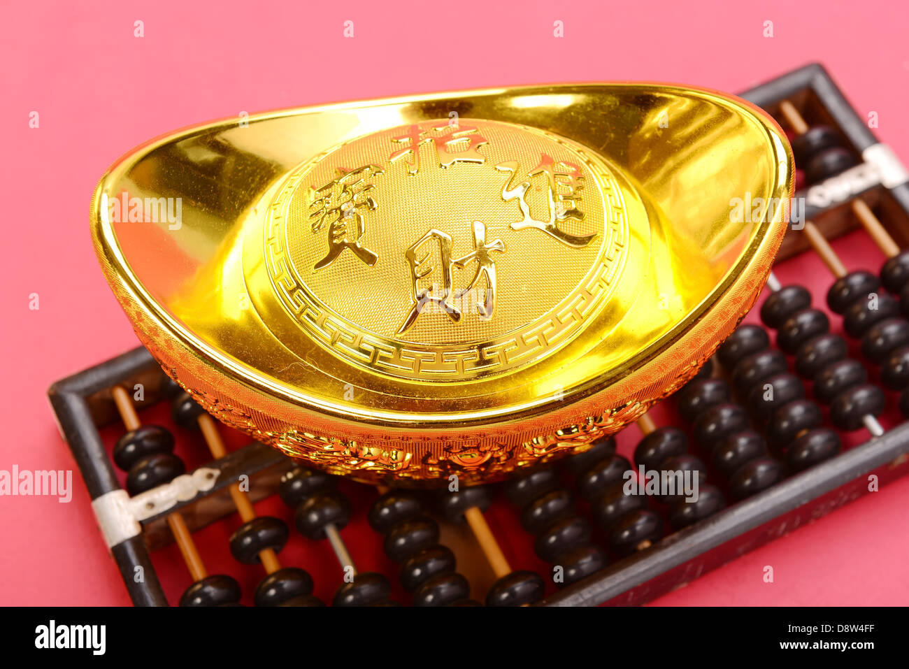 Chinese gold ingot and abacus mean symbols of wealth and prosperity. Stock Photo