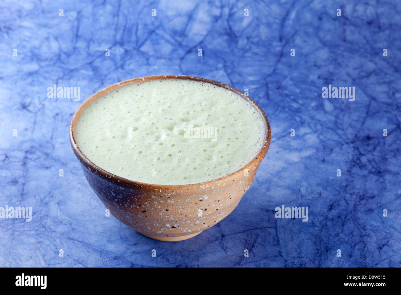 Matcha latte made with almond milk served in matcha bowl Stock Photo