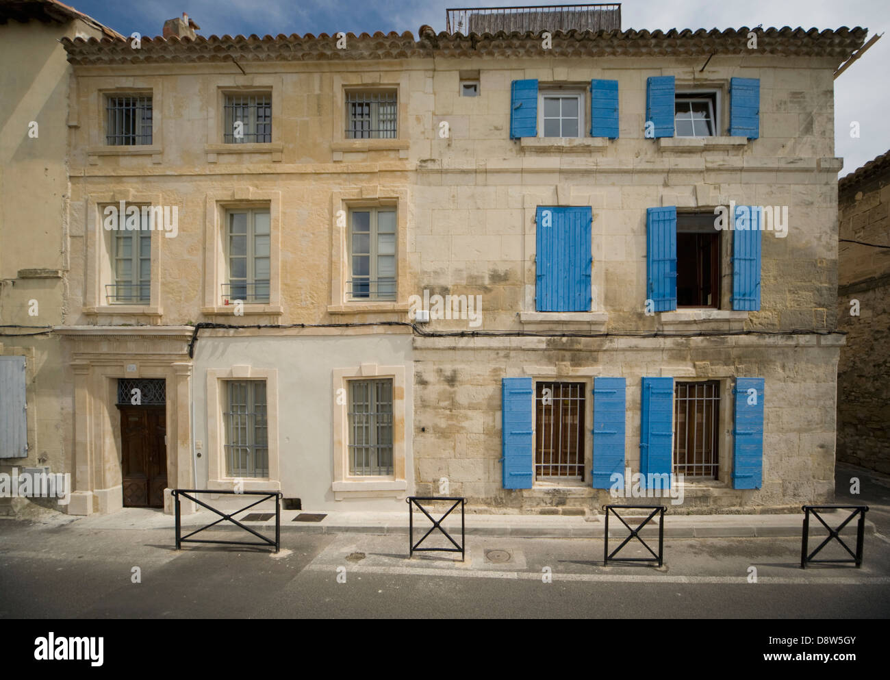 Two adjoining old stone 3storey houses in Arles, France, one with blue