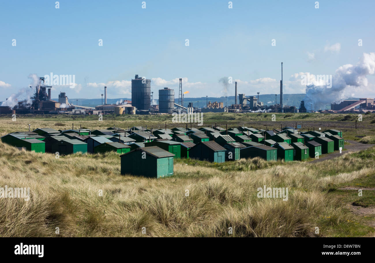 View over Fishermens Huts with Redcar Steelworks blast furnace in background. South Gare, Redcar, England, UK Stock Photo
