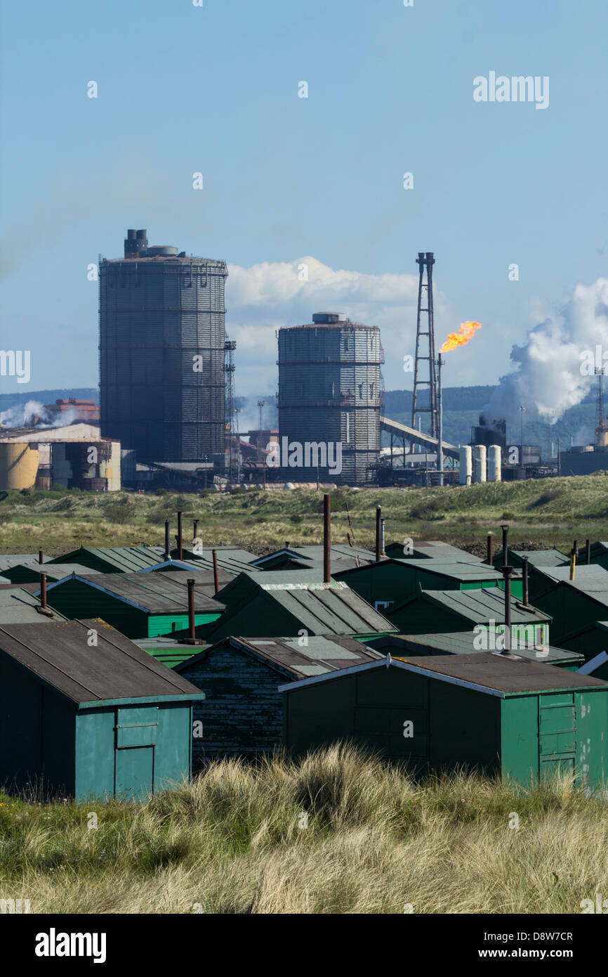 View over Fishermens Huts with Redcar Steelworks blast furnace in background. South Gare, Redcar, England, UK Stock Photo