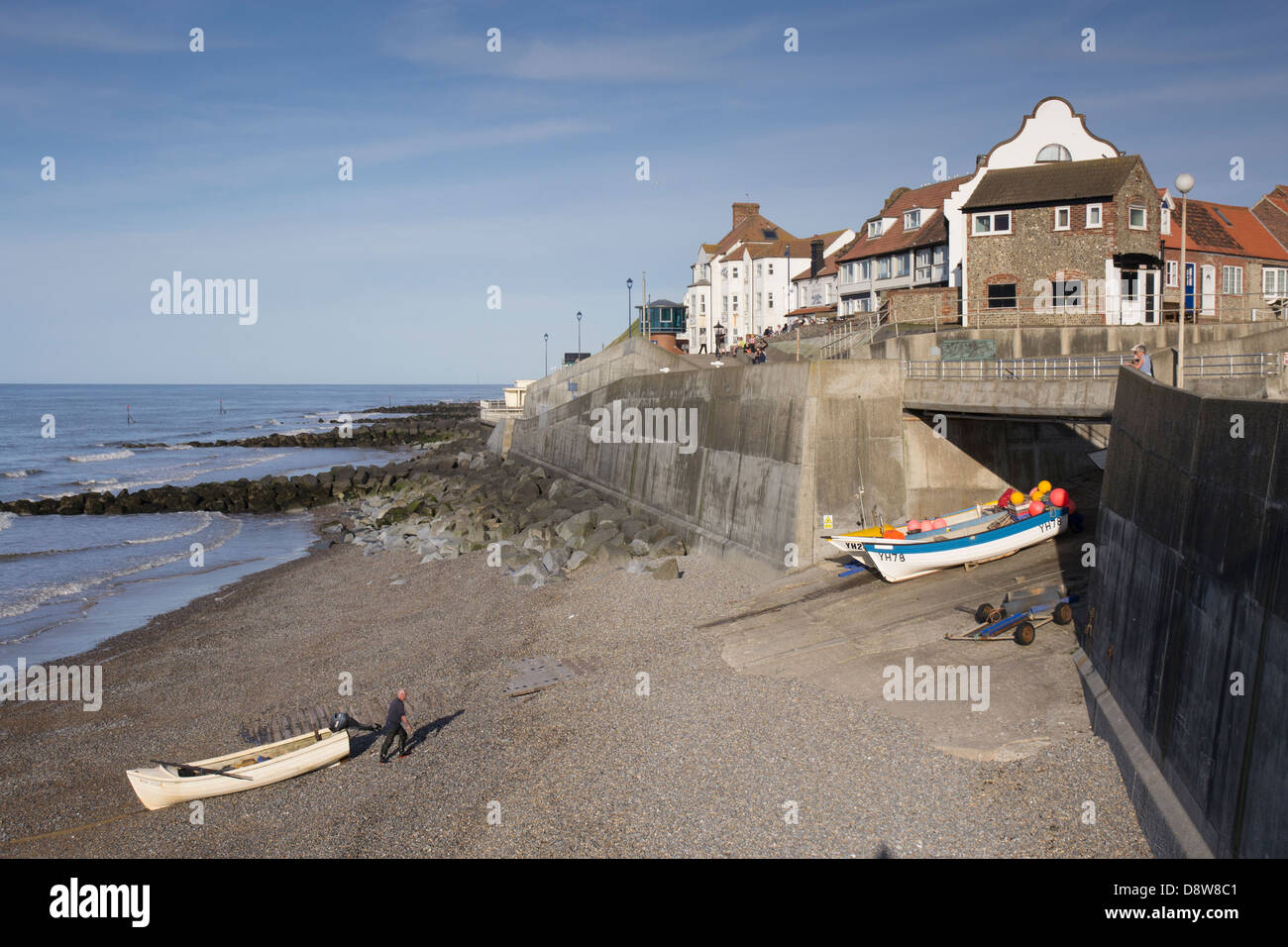 Fishermen hauling boat up the beach at Sheringham Norfolk coast Stock Photo