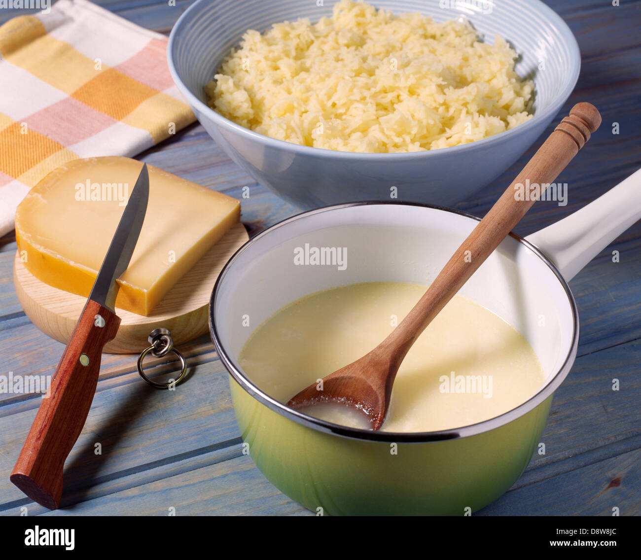 Heating the milk with the diced Gouda Stock Photo