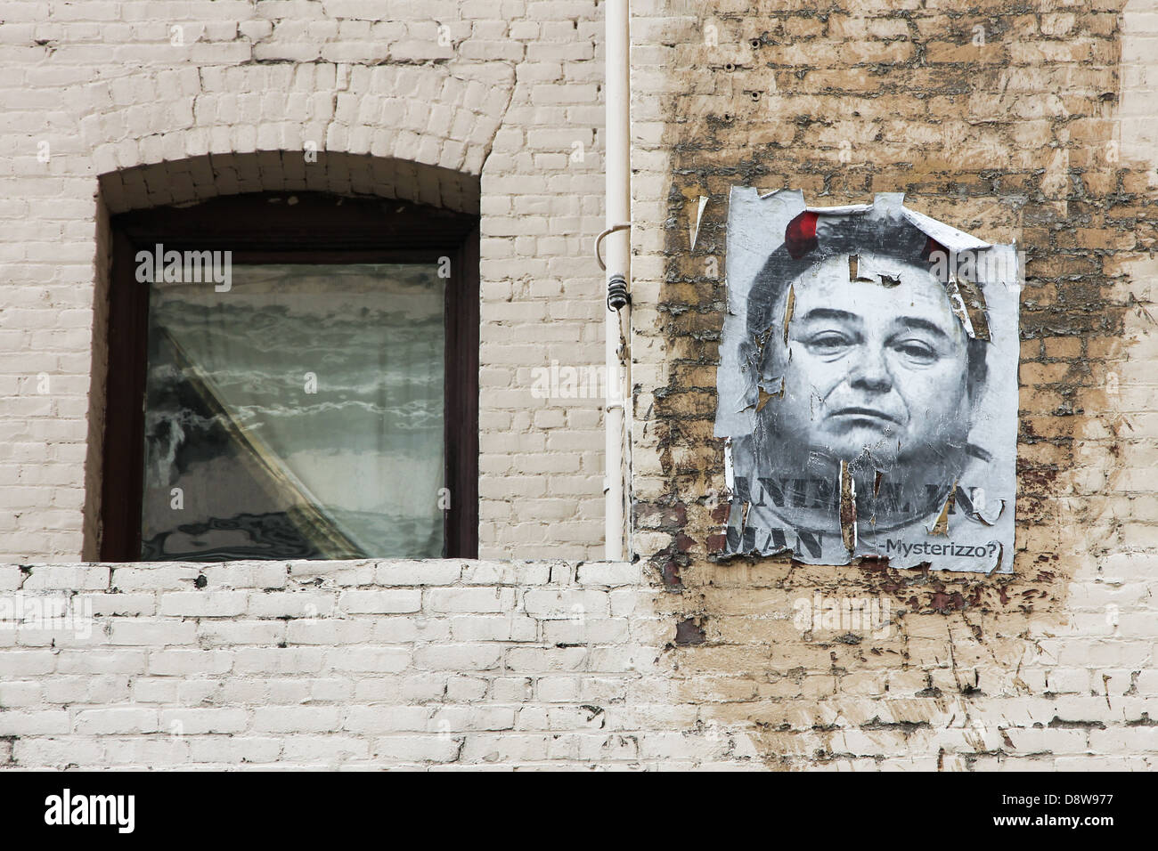 Mysterizzo Street Art in an alley way in Los Angeles Toy District, California, USA, a hand made poster by a window on a brick wall of an old building. Stock Photo