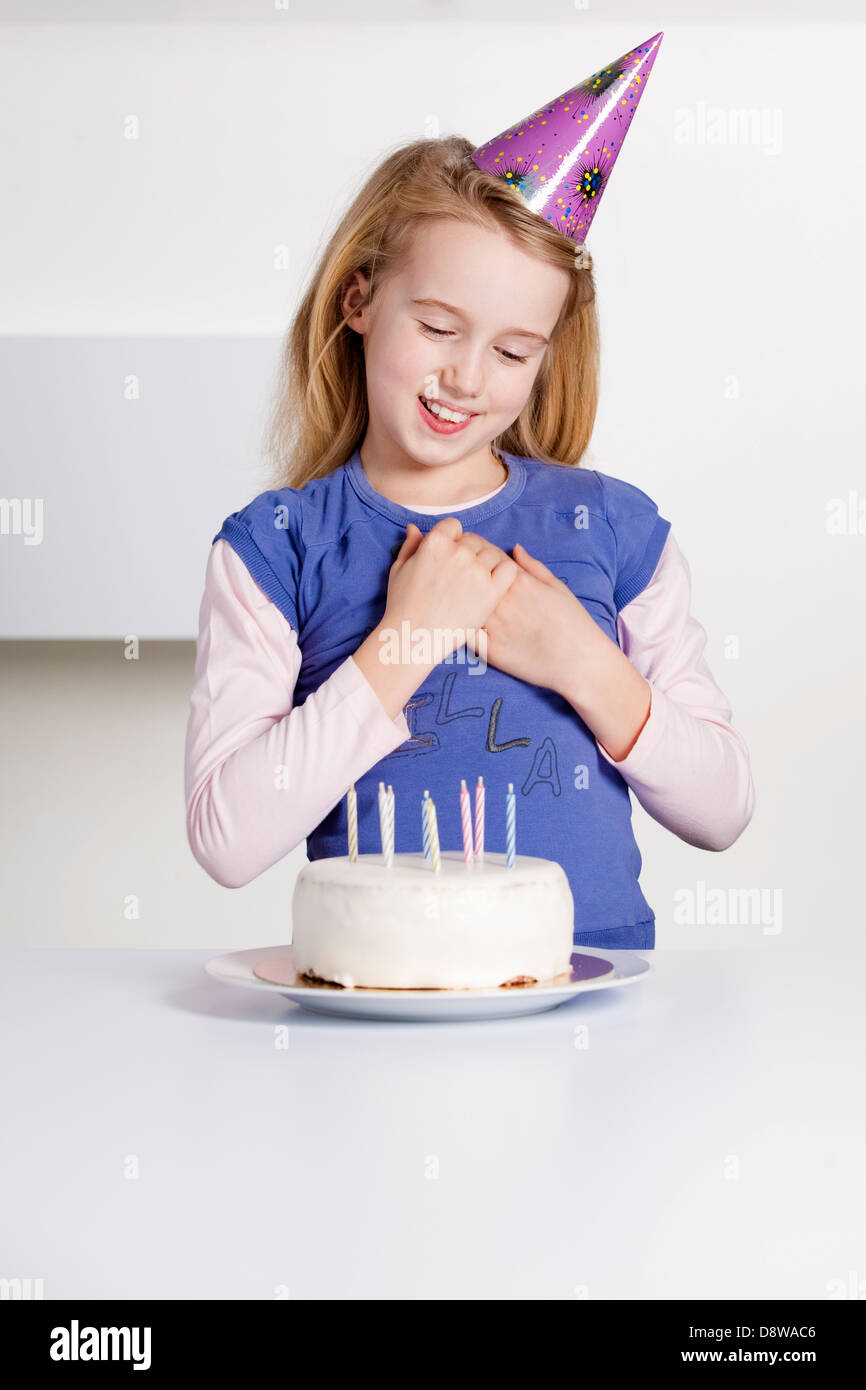 Young girl smiling infront of a Birthday cake Stock Photo - Alamy