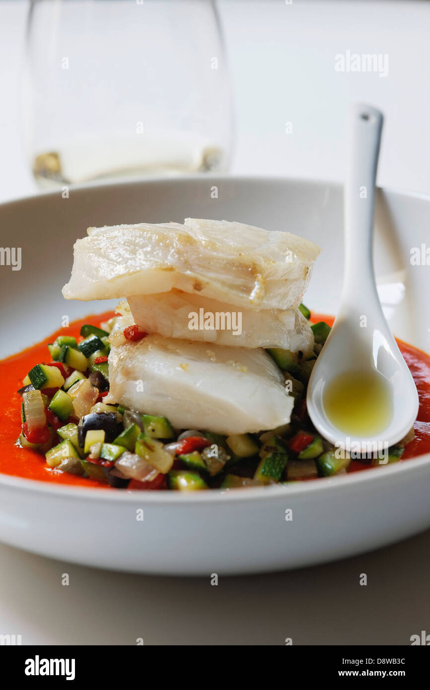 Piece of cod on a bed of diced southern vegetables Stock Photo