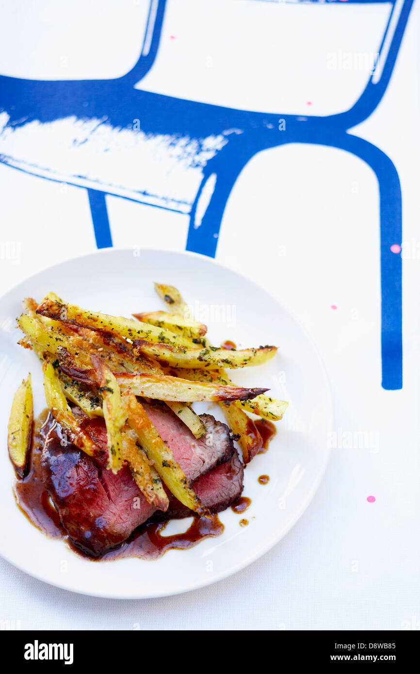 Roast beef with French fries cooked in the oven Stock Photo Alamy