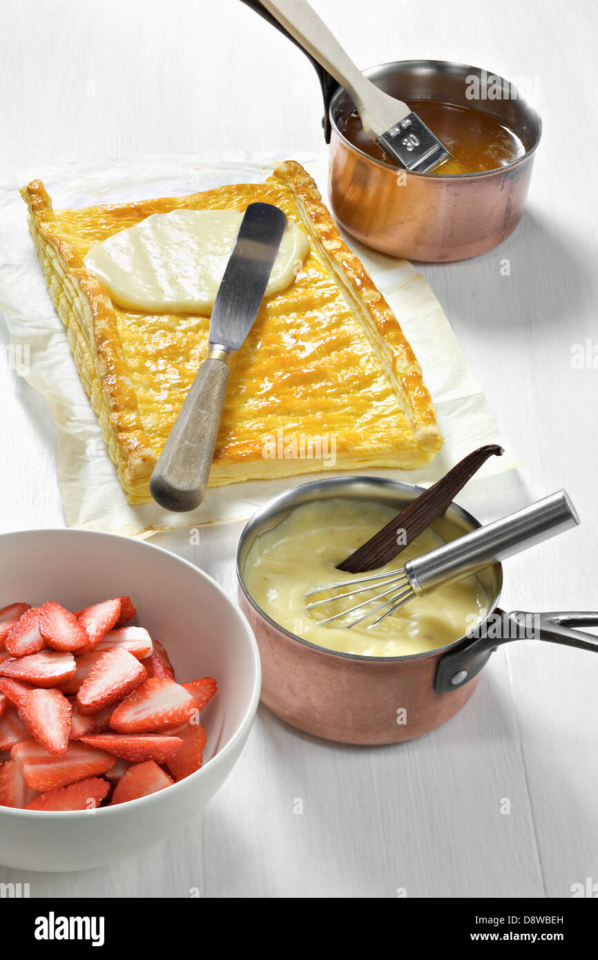 Spreading the confectioner's custard on the cooked flaky pastry Stock Photo
