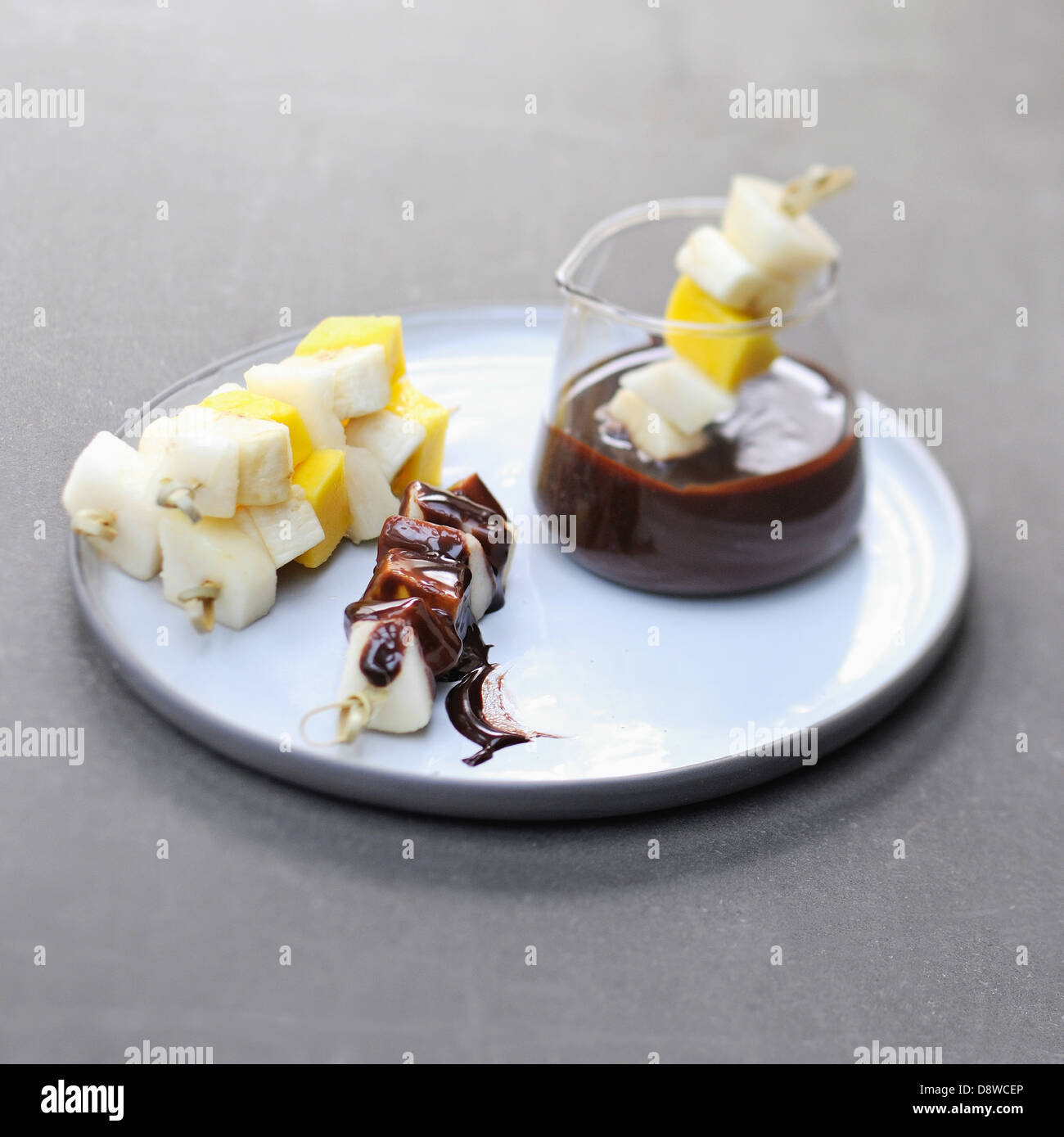 Fruit brochettes dipped in chocolate sauce Stock Photo