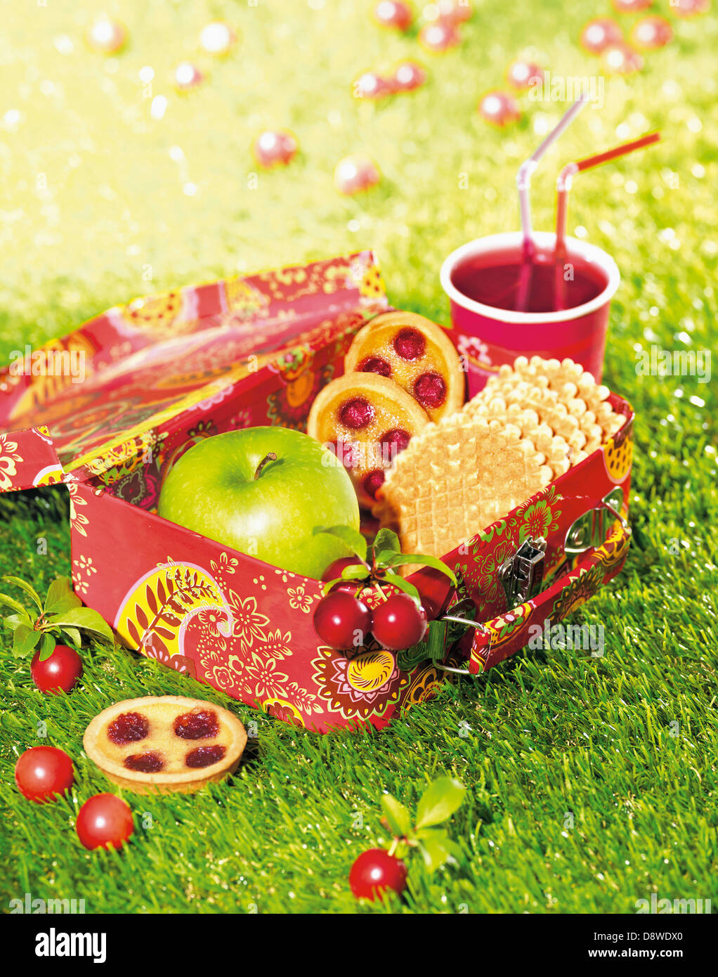 Cherry tartlets,waffles and an apple in a lunch box Stock Photo