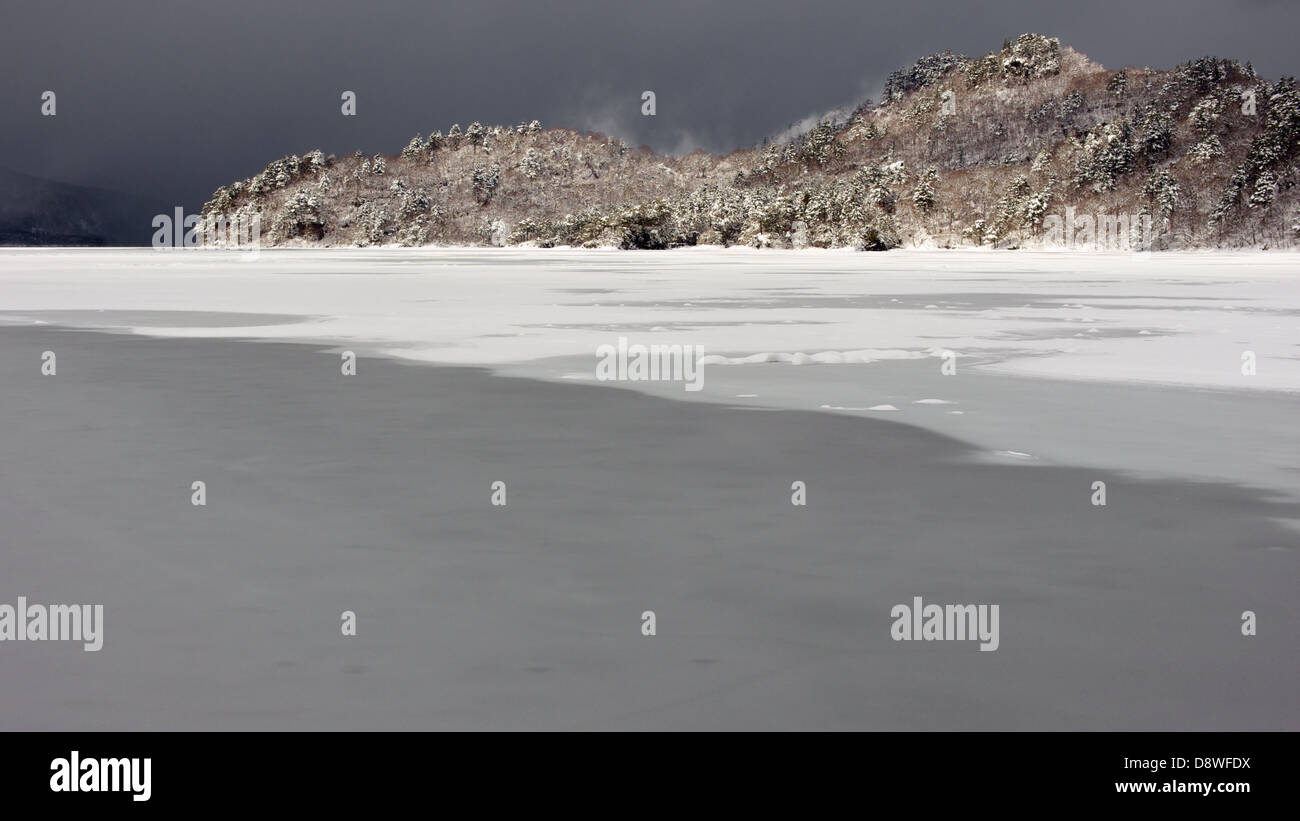 Dark skies over a frozen Lake Towada Stock Photo