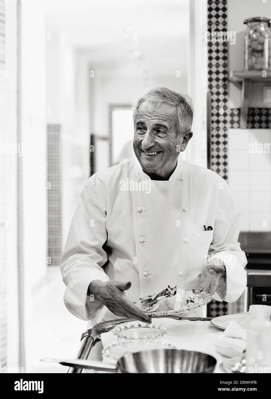 Michel Guérard presenting a dish of food in his kitchen Stock Photo