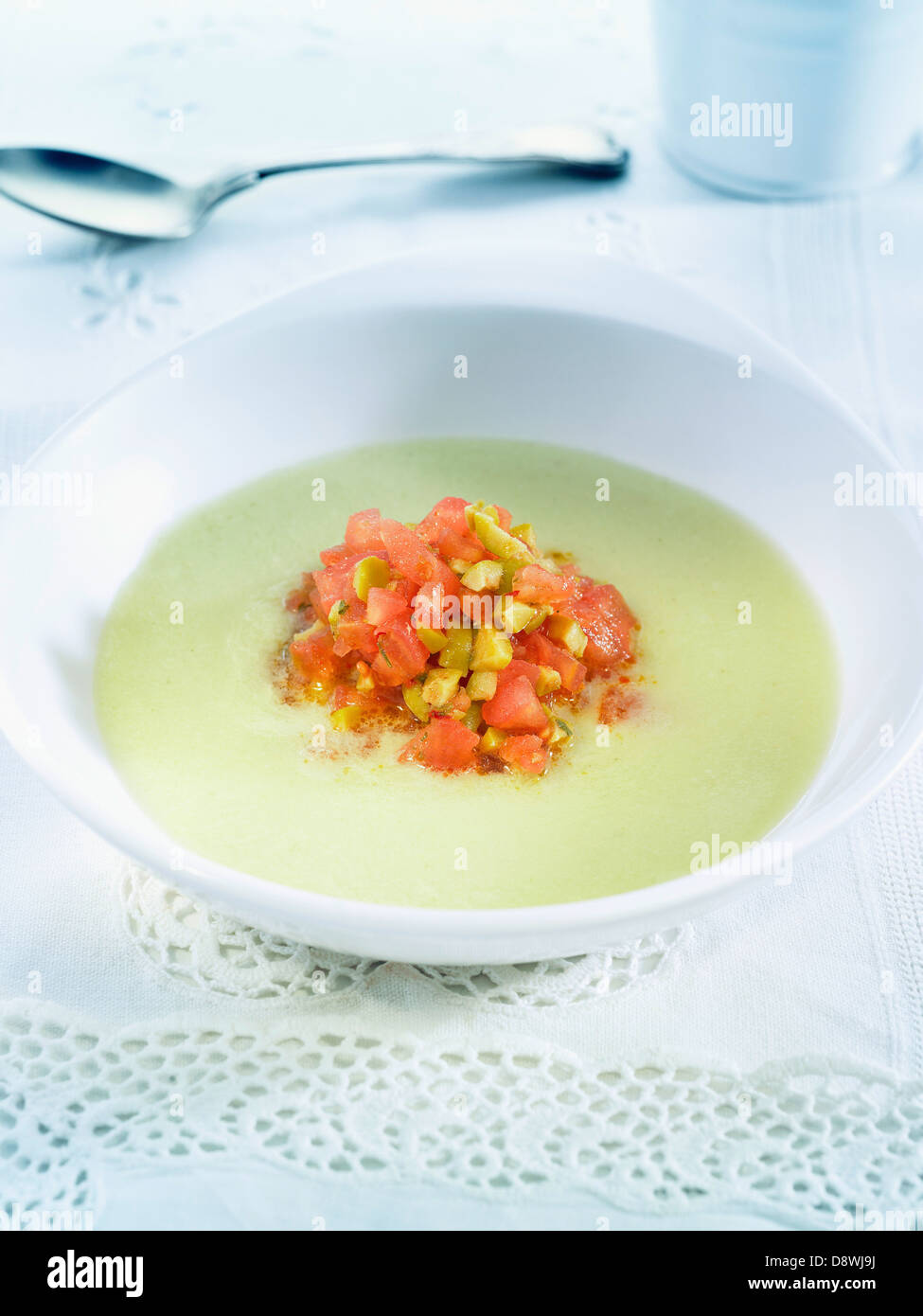 Cream of celeriac and cucumber soup with diced tomatoes and green olives Stock Photo