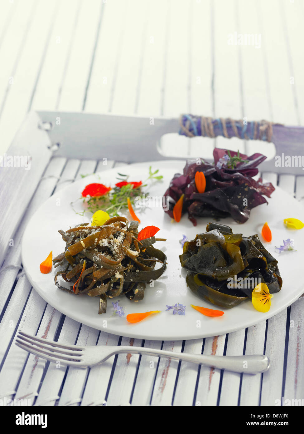 Wakame seaweed nest and sea thong nests with flower petals Stock Photo