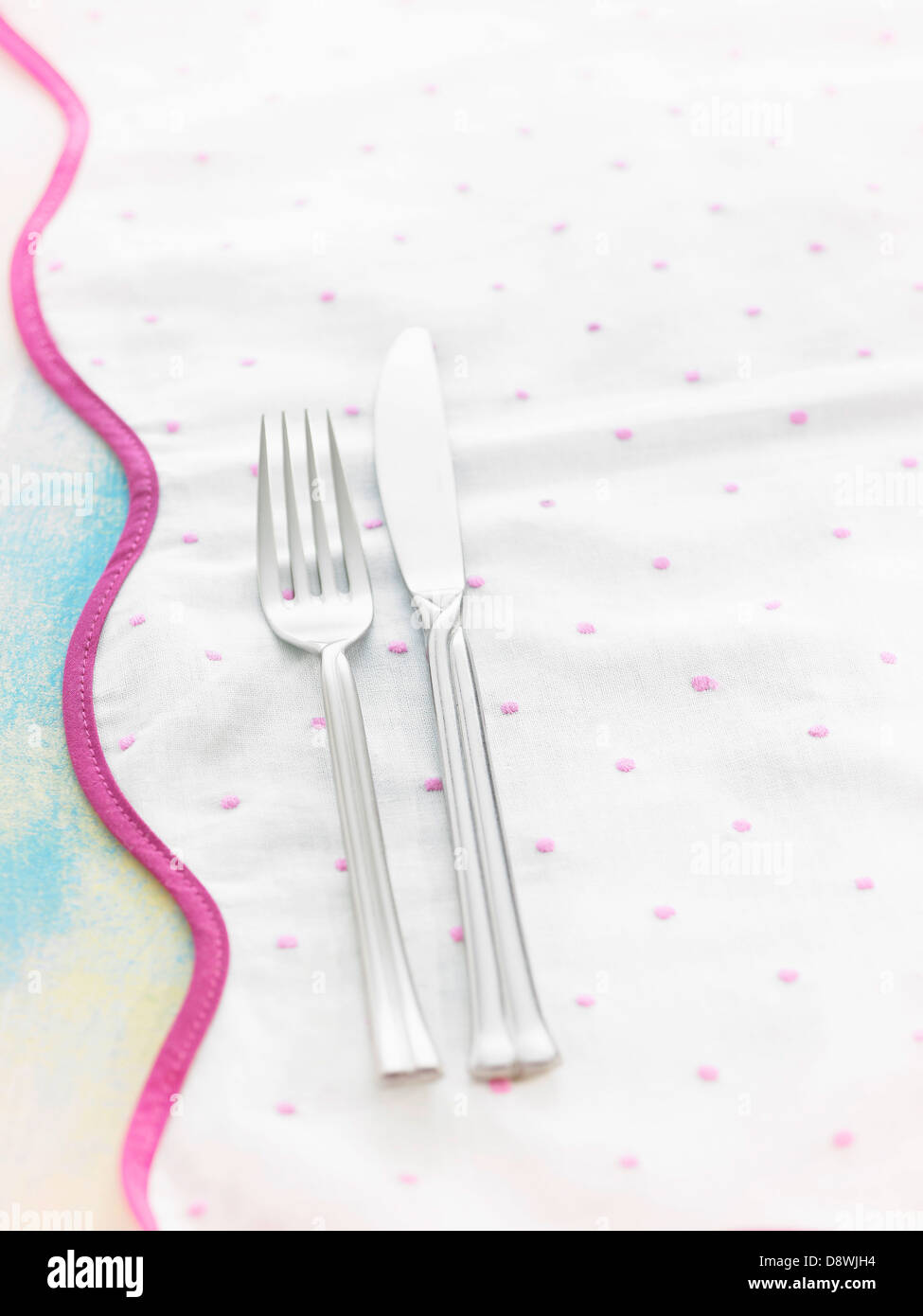 Knife and fork on a tablecloth Stock Photo