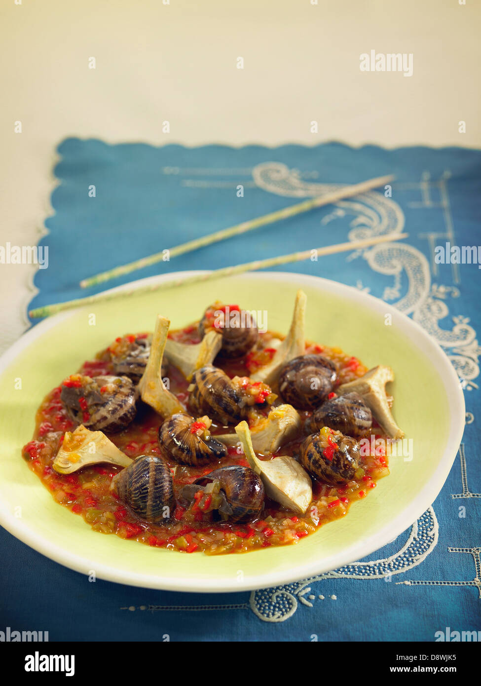 Snails with artichokes,tomato sauce with Vermouth and thinly chopped vegetables Stock Photo