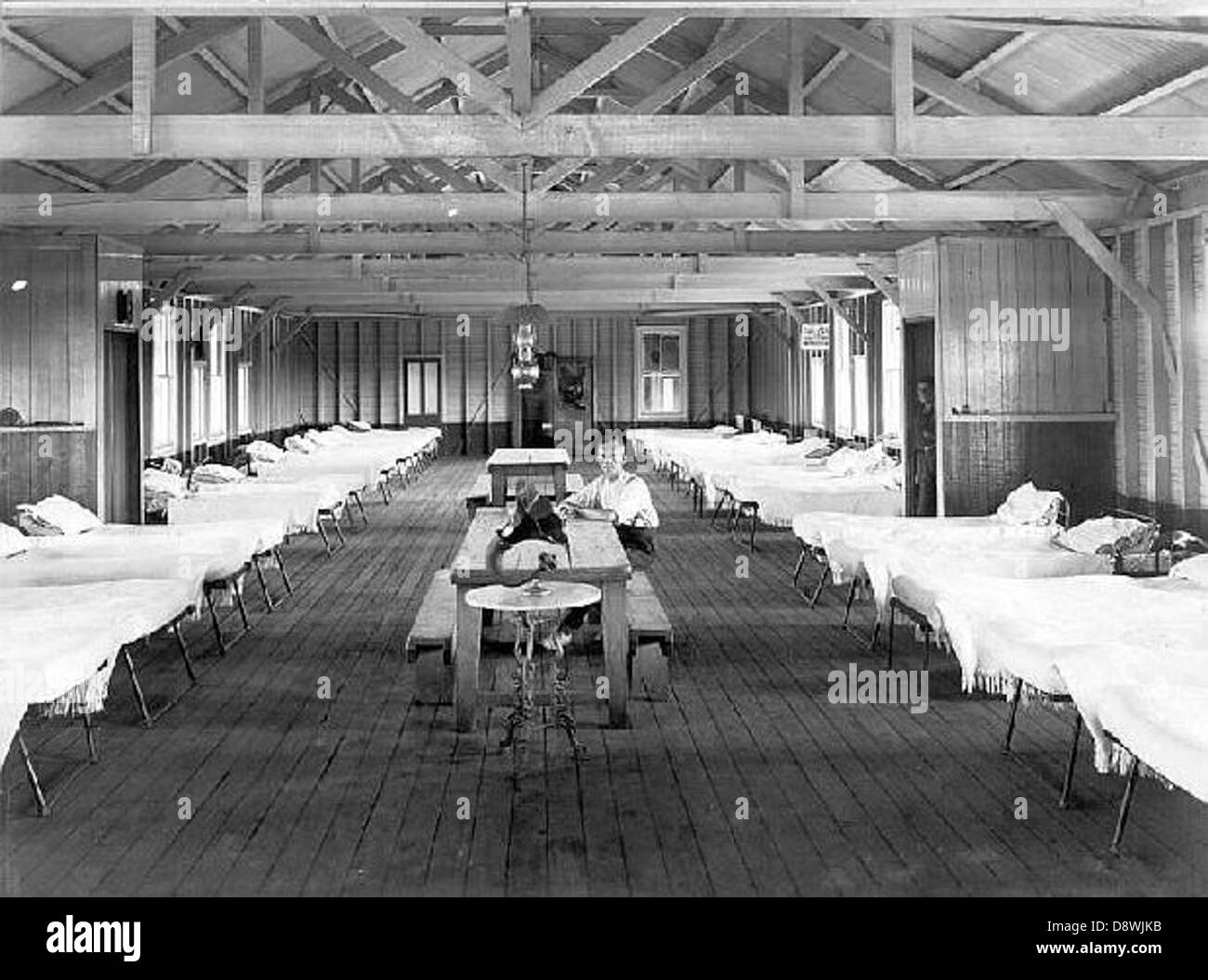 This black-and-white photograph depicts the dormitory at Scheyville, a historic training farm in Hawkesbury, New South Wales. It shows children and workers involved in farm training, providing a glimpse into the lives of those involved in the agricultural education program at the state-run facility in the mid-20th century. Stock Photo