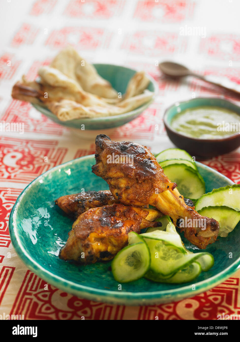 Tandoori chicken with sliced cucumber Stock Photo